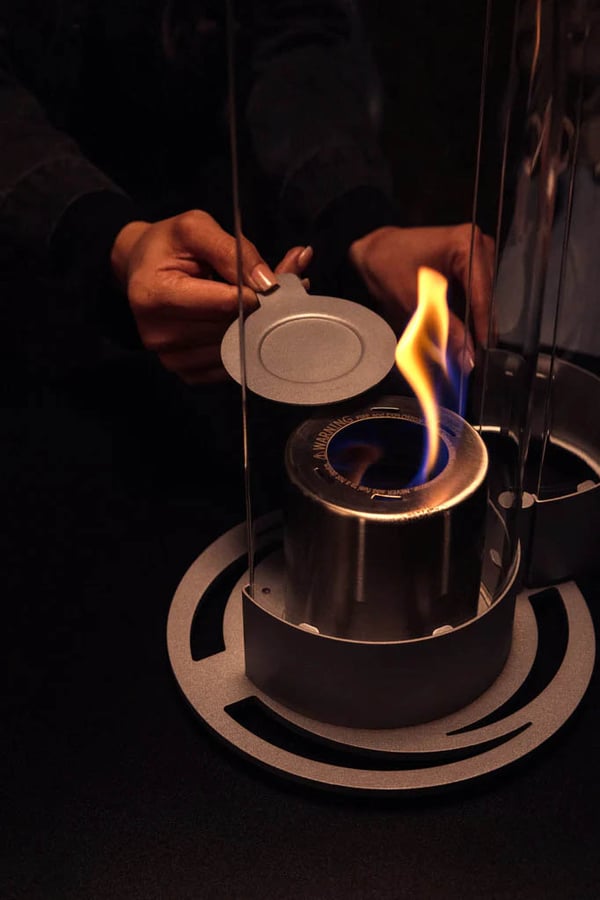 A metal plate to extinguish the flame is stored in the base